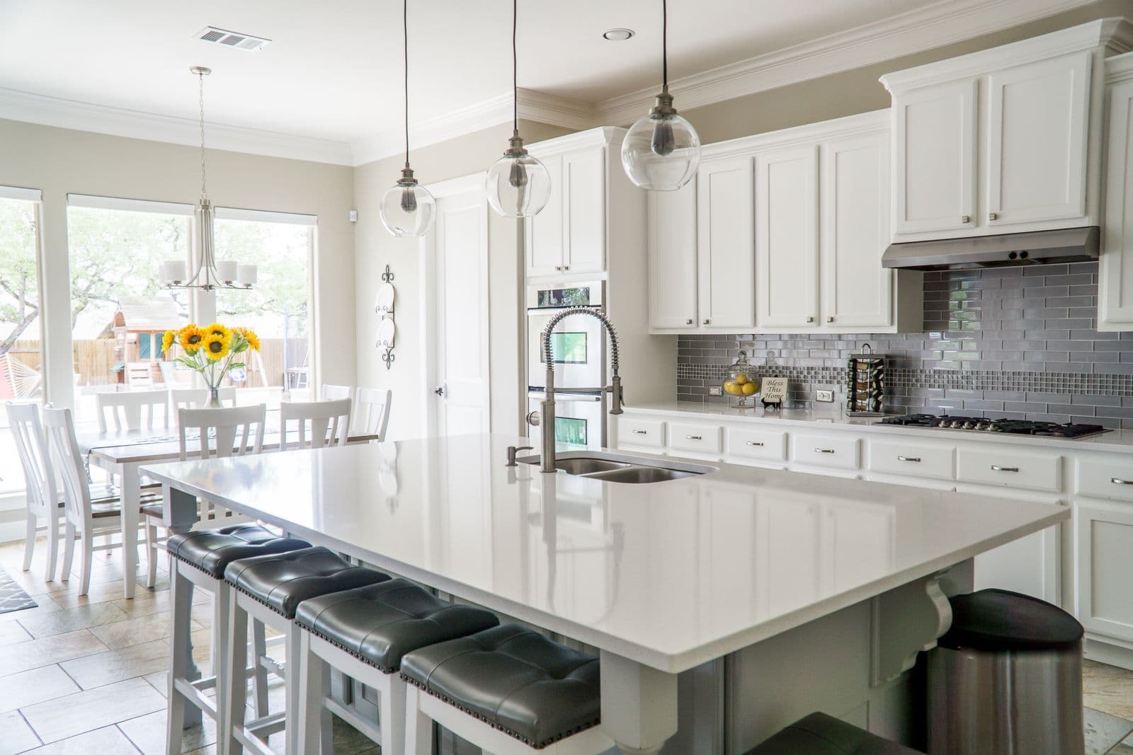 Bright modern residential kitchen with an island sink and faucet. Stock photograph; not a SpenceCo project.